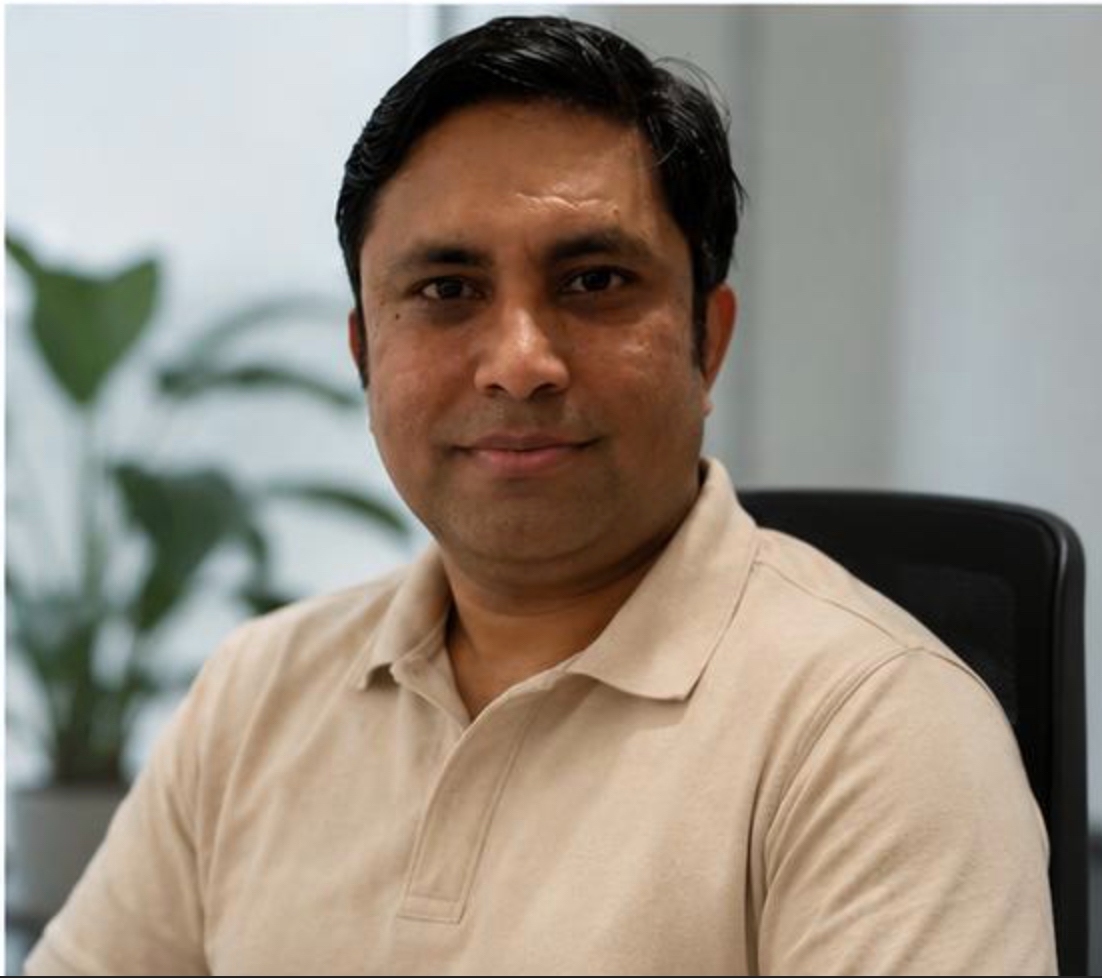 Portrait of author Venkat seated and smiling toward the camera